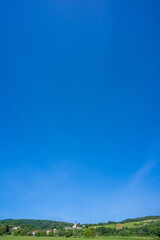 Ninimalist photo of a typical French village with the church perched on the hill ( Rignat, Ain, France).