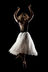 Fototapeta na wymiar ballerina with a white dress and black top posing on black background
