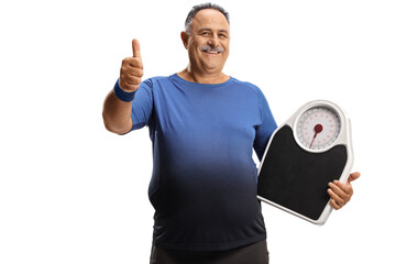 Mature man in sportswear holding a weight scale and gesturing a thumb up sign