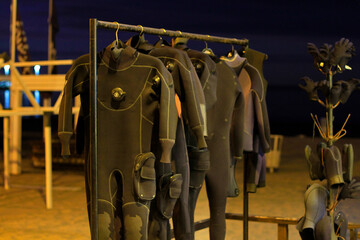 Naklejka premium black neoprene hanging wetsuits for use at sea