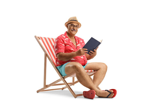 Mature male tourist with a book sitting in a bech chair and looking at camera