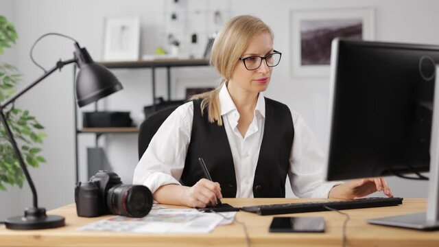 Woman retouching photos at office