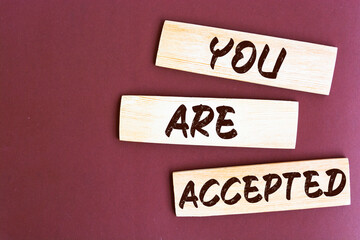 Obraz premium YOU ARE ACCEPTED text on a wooden cubes on a brown background