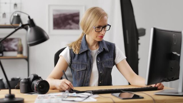 Woman retouching photos at office