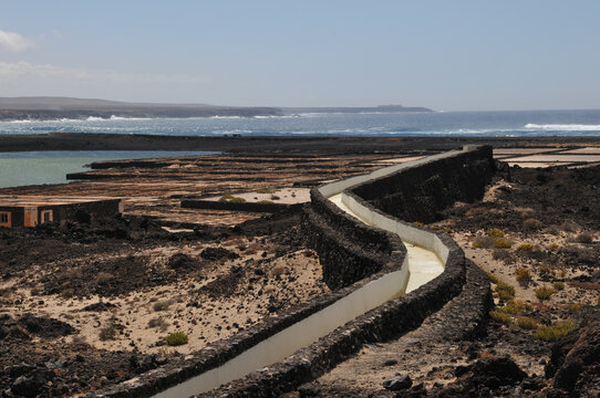 Long Swirly Road In The Middle Of A Big Rocky Island Next To The Clear Blue Ocean