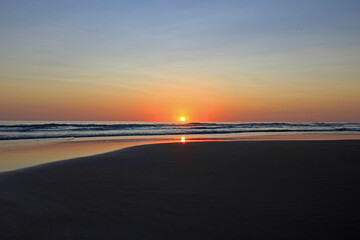 Fototapeta na wymiar Colorful sunset on the shore of the ocean