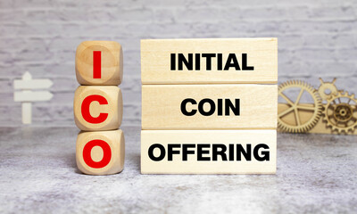 ICO abbreviation stands for Initial Coin Offering on wooden blocks, yellow background. Cryptocurrencies concept