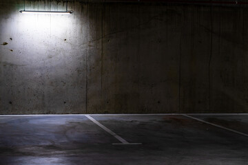 Empty parking lot with overhead dim light, underground parking garage