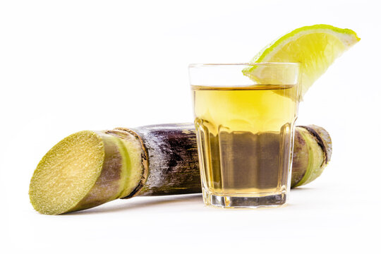 Brazilian pinga cup on isolated white background with sugar cane on the side.