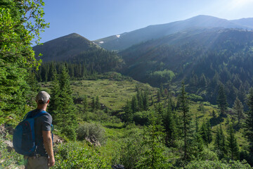 Naklejka premium Hiker looking out on mountain scene in Colorado valley