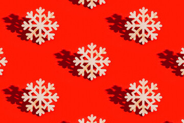 Naklejka na ściany i meble Christmas pattern with wooden snowflake on red Decoration for winter celebration New Year holiday concept.
