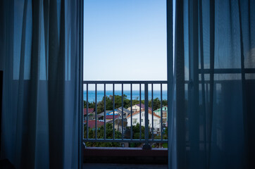 morning ocean and town scape trough window and curtains of hotel in chiba, japan