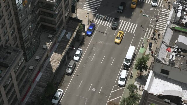 A top down high angle view of a busy Manhattan street during the day.  	