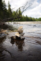 A small inukshuk along the side of a river in rural Ontario, Canada. A traditional symbol of the Indigenous people who used to live here.