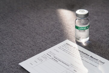 Covid-19 vaccine bottle and Covid-19 vaccination card form. Health guarantee for travel and...