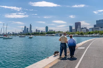 Foto op Aluminium A senior couple enjoys a walk with their dog in Chicago, along the Lakefront Trail, on a lovely summer day. © Page Light Studios