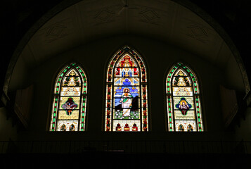 three stained glass windows on church interior
