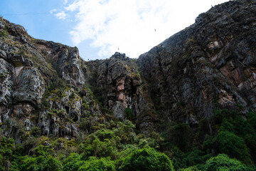 Photograph of mountains with pine trees along with a cloudy blue sky in Nemocón Colombia.