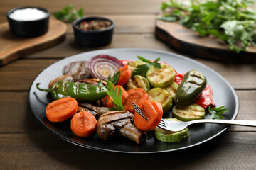 Delicious grilled vegetables with parsley on wooden table, closeup