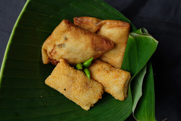 Fried food isolated on a black background. Fried foods are a popular snack. Fried food vendors can be found on the side of the road or around on a pole or cart. The ingredients are floured and fried. 