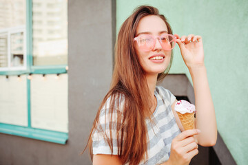 Funny teen girl in cool hipster sunglasses eating ice cream cone. Summer food