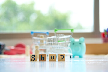 Alphabet SHOP on wood cubic block and basket cart for shopping concept
