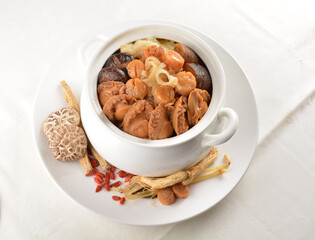 Chinese traditional luxury cuisine buddha jump over the wall with seafood abalone, sea cucumber, shark's fin, scallop and meat in hot herbal soup clay pot in white gold background asian menu for new y