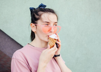 Funny teen girl in cool hipster sunglasses eating ice cream cone. Summer food