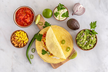 Tortilla wrap or burrito with corn, beans, greens, and homemade guacamole.
