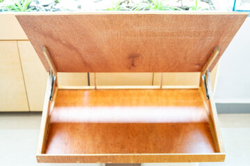 A drawing desk with opened top showing compartment inside.