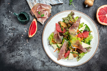 Prosciutto crudo ham salad with brie camembert cheese and grapefruit, salad mix. Healthy food, banner, menu, recipe place for text, top view