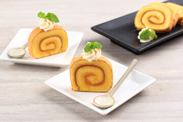 Slice Pineapple Roll Cake or Bolu Gulung Nanas, Thin Cake Rolled with PIneapple Jam with Cheese Frosting on Top.