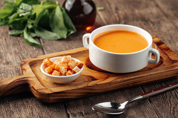 Lentil cream soup with dill and croutons on wooden background