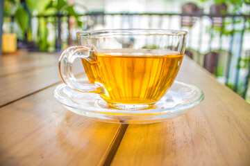 Cup of hot tea on a wooden table outdoors morning narrow depth of field