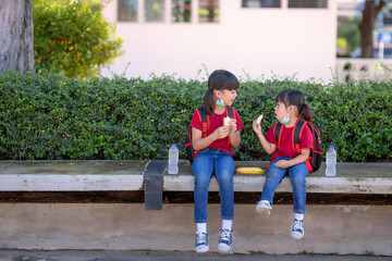 Kids eating outdoors at the school. Healthy school breakfast for children. Sandwich time.