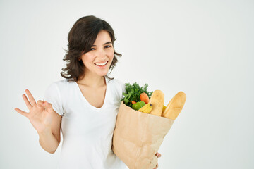 cute brunette in white t-shirt package with vegetables groceries supermarket