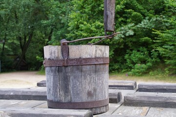 Fototapeta premium old wooden bucket standing on the lid of a village well 