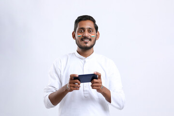 young indian man celebrating independence day or republic day and using smartphone.