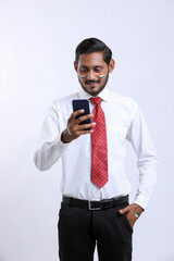Young indian businessman or employee using smartphone.