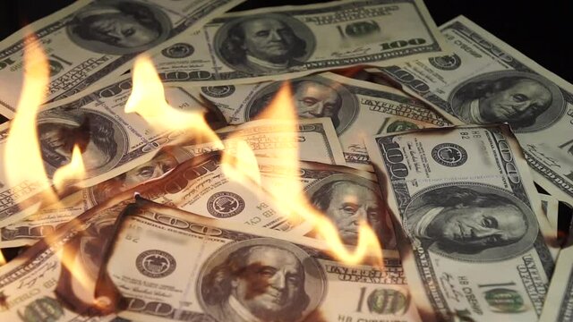 Slow motion of dollars money on fire lost money