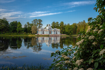 Fototapeta na wymiar Pavilion Grotto on the shore of a large pond in the Catherine Park in Tsarskoye Selo on a sunny summer evening. Pushkin, St. Petersburg. Russia