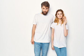 Fototapeta premium cheerful young couple in white t-shirts embrace friendship lifestyle