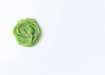 Gel texture with small particles of green scrub on a white background. Skin cleansing cream and copy space