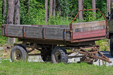 An old tractor trailer is parked on a rural street