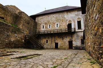 Magnificent view of courtyard with ancient stone building in the medieval castle. High stone wall...