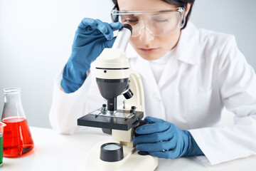 Woman in white coat laboratory microscope work science research