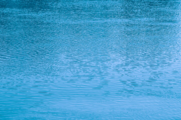 Blue water background. The calm surface of the sea. Ocean. Natural abstract background. Film grain and noise.
