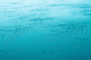 Blue water background. The calm surface of the sea. Ocean. Natural abstract background. Film grain and noise.