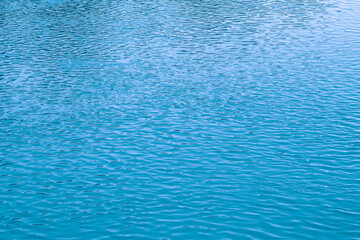 Blue water background. The calm surface of the sea. Ocean. Natural abstract background. Film grain and noise.