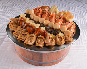 stewed braised luxury Peng cai with mixed seafood tiger prawn, scallop, abalone, duck and pork meat, sea cucumber, fish maw, dried oyster in superior hot soup clay pot chinese menu for cny festival
